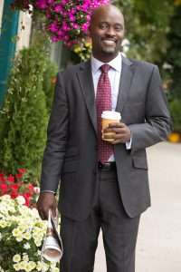 Adam Stanley in suit with coffee