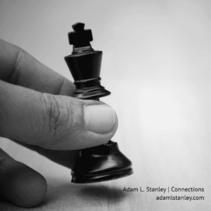 photo of a white male hand with a chess piece.
